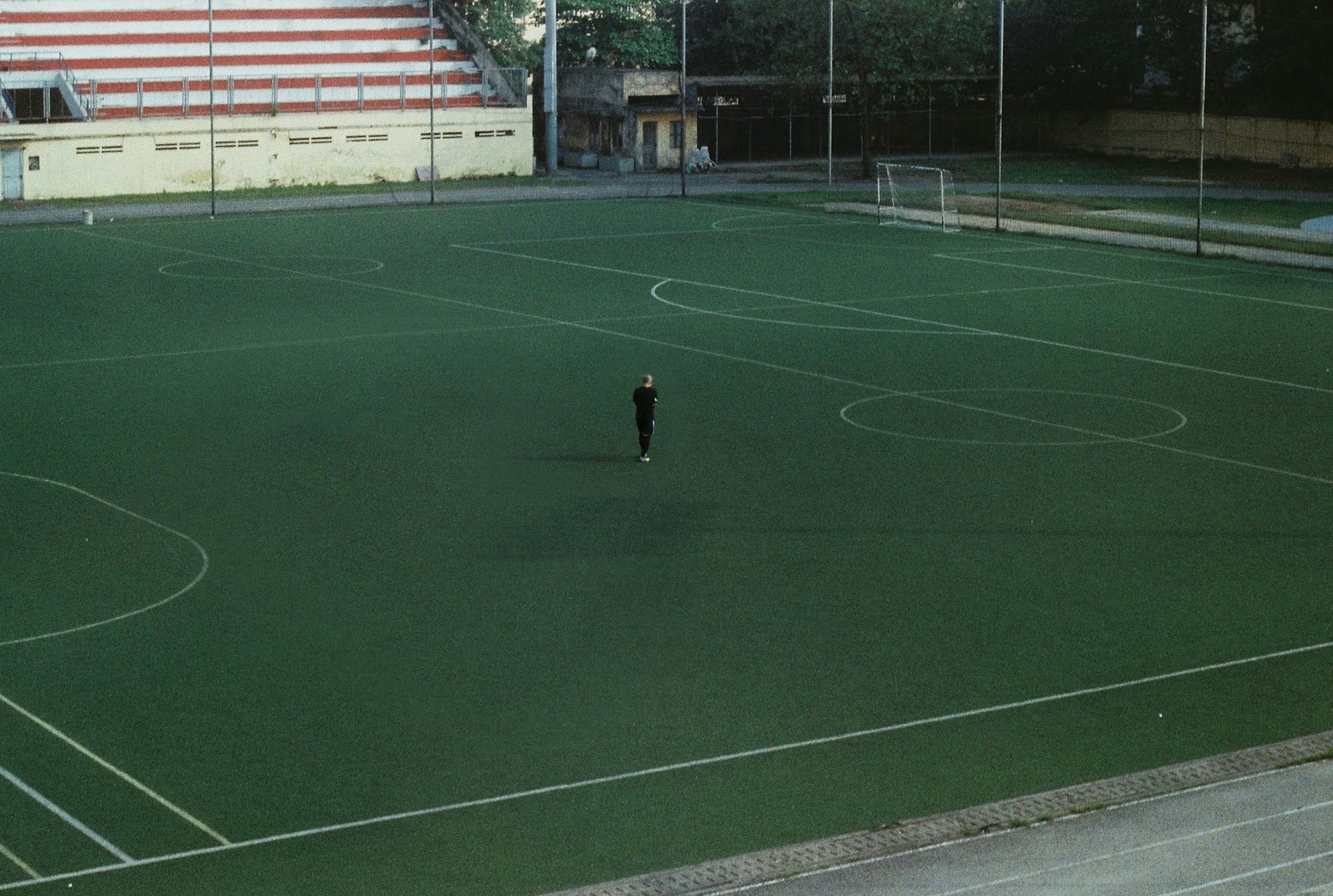 Professional football player standing alone on an empty stadium field