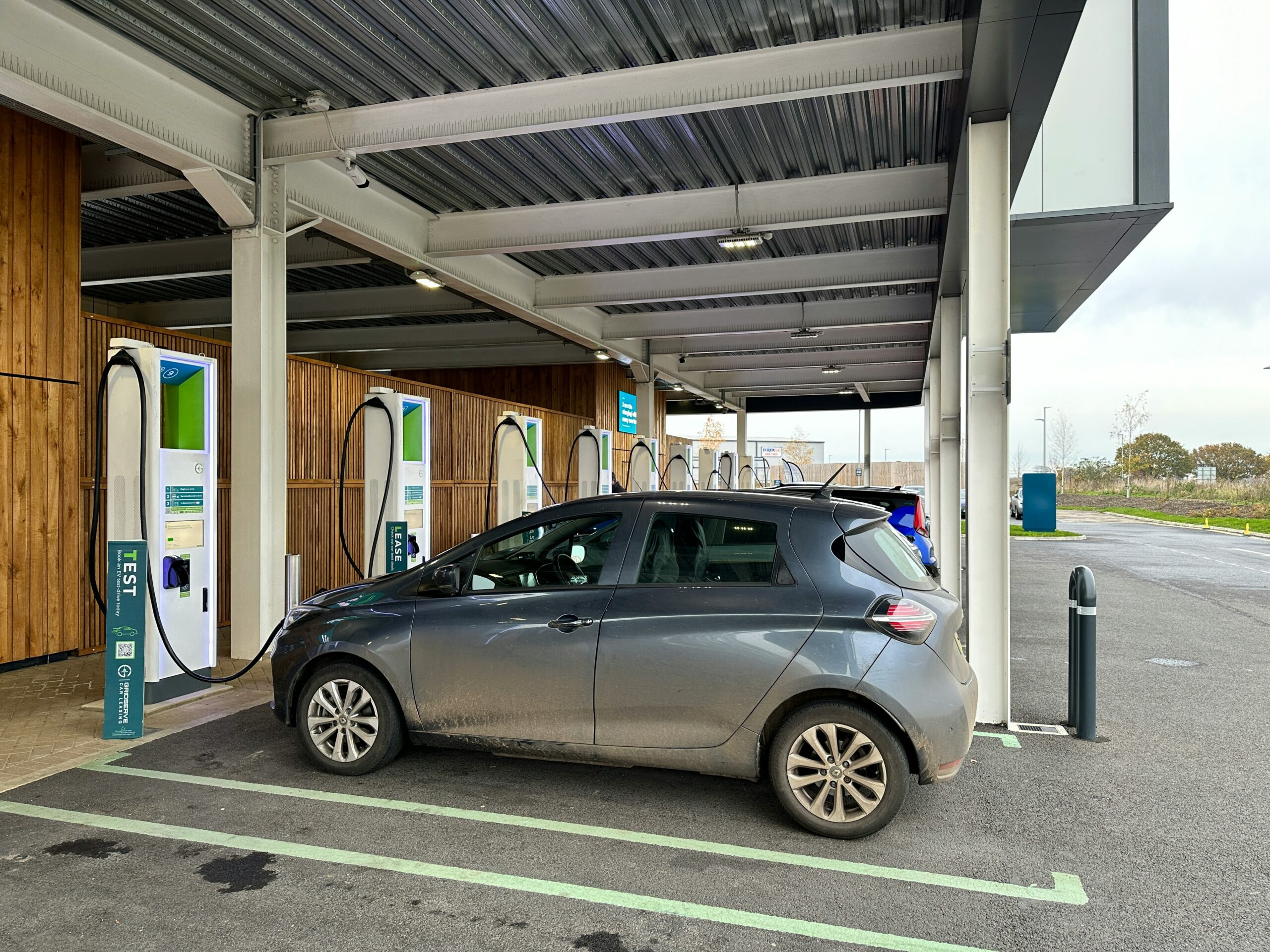 Modern electric car parked near charging station.